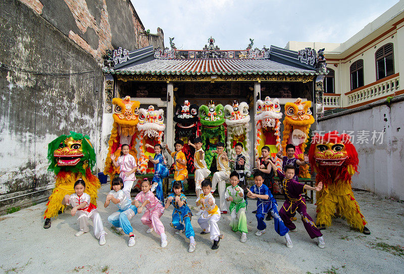 中国功夫少年和舞狮在槟榔屿楼Pun Hong庙前表演。